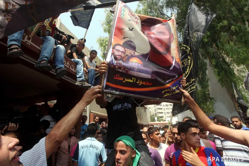 Palestinians hold pictures of Palestinian soccer player Mahmoud Al-Sarsak upon his arrival in Gaza City July 10, 2012. Israel released the Gaza soccer player on Tuesday in a deal to end his intermittent four-month hunger...