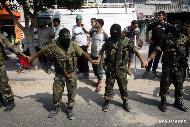 Palestinian militants of Islamic Jihad movement stand attention as Palestinian soccer player Mahmoud Al-Sarsak arrives to Rafah, southern Gaza strip on July 10, 2012 upon his release from Israeli prison. Sarsak staged a...