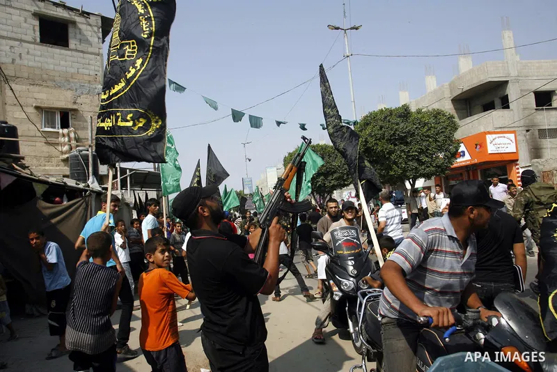 A Palestinian militant fires bullets as Palestinian soccer player Mahmoud Al-Sarsak arrives to Rafah, southern Gaza strip on July 10, 2012 upon his release from Israeli prison. Sarsak staged a hunger strike of nearly thr...
