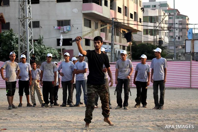 A Palestinian trainer plays martial sport during training in a summer camp organized by Hamas movement at Shati refugee camp in Gaza City July 10, 2012. Hamas movement organized dozens of summer camps for Palestinian chi...