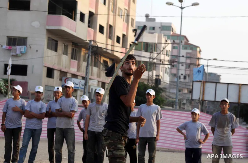 A Palestinian trainer plays martial sport during training in a summer camp organized by Hamas movement at Shati refugee camp in Gaza City July 10, 2012. Hamas movement organized dozens of summer camps for Palestinian chi...