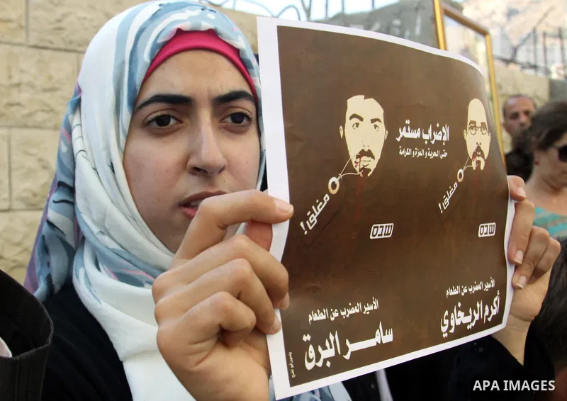 Palestinian protestors hold pictures of Palestinian prisoners in Israeli jails whose are still refusing food for after a deal was made to end a mass prisoner hunger strike, during a demonstration in their support, in the...