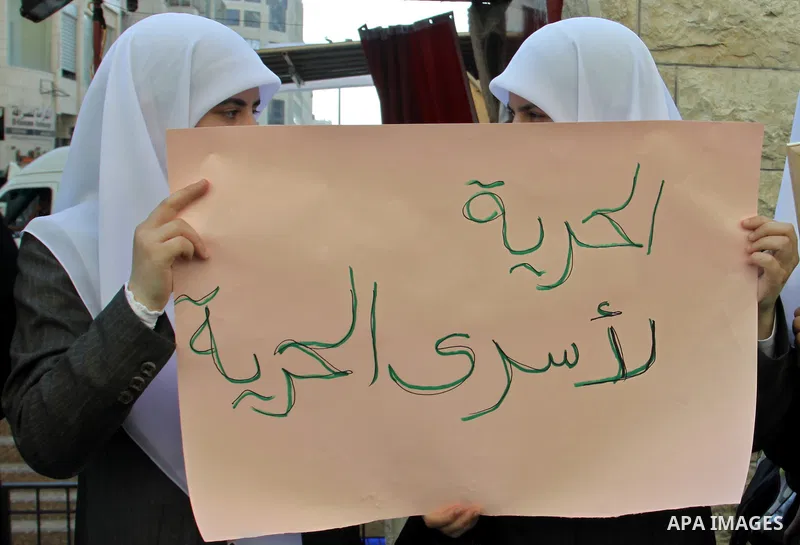 Palestinian protestors hold pictures of Palestinian prisoners in Israeli jails whose are still refusing food for after a deal was made to end a mass prisoner hunger strike, during a demonstration in their support, in the...