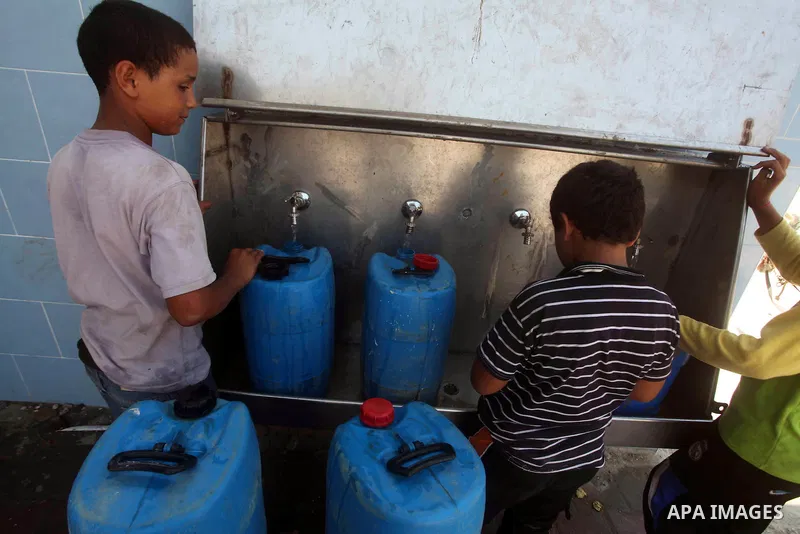 Palestinian children fill their bottles a potable water at a water purification station, in Deir al-Balah central Gaza Strip, on July 11. 2012. Palestinians suffer from the severe lack of potable water. Photo by Ashraf A...