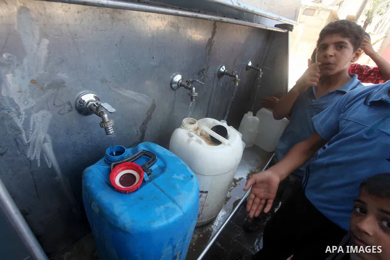 Palestinian children fill their bottles a potable water at a water purification station, in Deir al-Balah central Gaza Strip, on July 11. 2012. Palestinians suffer from the severe lack of potable water. Photo by Ashraf A...