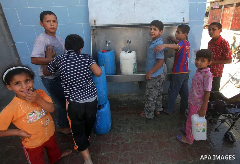 Palestinian children fill their bottles a potable water at a water purification station, in Deir al-Balah central Gaza Strip, on July 11. 2012. Palestinians suffer from the severe lack of potable water. Photo by Ashraf A...