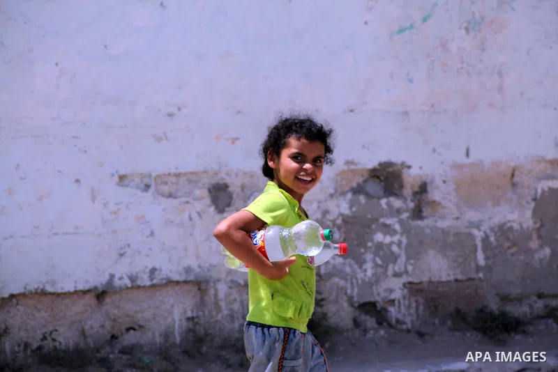 A Palestinian child carries her bottles a potable water from a water purification station, in Deir al-Balah central Gaza Strip, on July 11. 2012. Palestinians suffer from the severe lack of potable water. Photo by Ashraf...