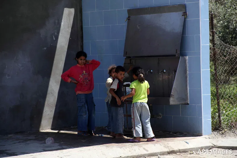 Palestinian children fill their bottles a potable water at a water purification station, in Deir al-Balah central Gaza Strip, on July 11. 2012. Palestinians suffer from the severe lack of potable water. Photo by Ashraf A...