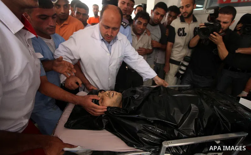 Palestinian medics wheel a Hamas militant into al-Shifa Hospital following an Israeli attack in Gaza City on July 12, 2012. A Palestinian militant from the ruling Hamas movement was killed and two others wounded on Thurs...
