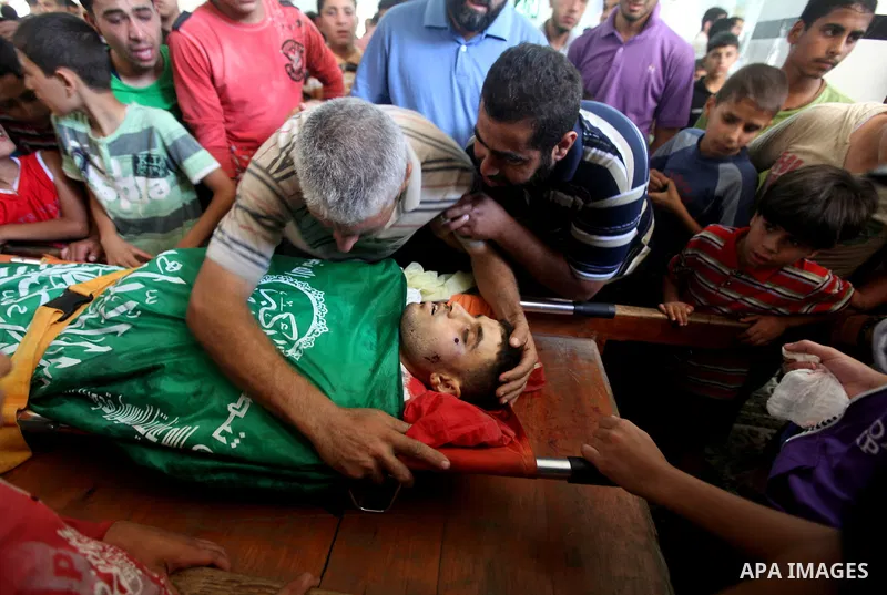Palestinians mourn over the body of Hamas militant Mahmud Al-Heggi during his funeral in the Al Zaitun area in the east of Gaza city, 12 July 2012. Al Heggi was killed and others wounded after an Israeli air strike in AL...