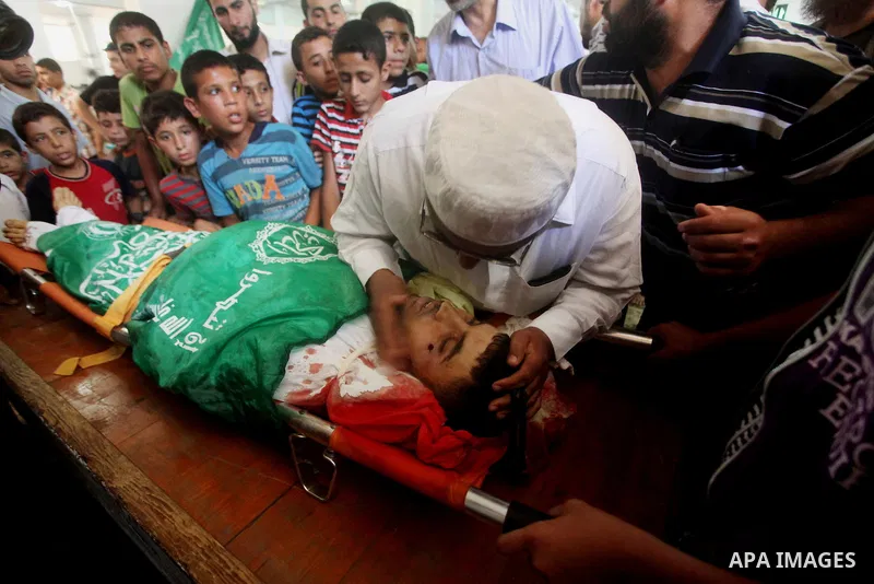 Palestinians mourn over the body of Hamas militant Mahmud Al-Heggi during his funeral in the Al Zaitun area in the east of Gaza city, 12 July 2012. Al Heggi was killed and others wounded after an Israeli air strike in AL...