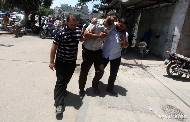 Palestinians mourn over the body of Hamas militant Mahmud Al-Heggi during his funeral in the Al Zaitun area in the east of Gaza city, 12 July 2012. Al Heggi was killed and others wounded after an Israeli air strike in AL...