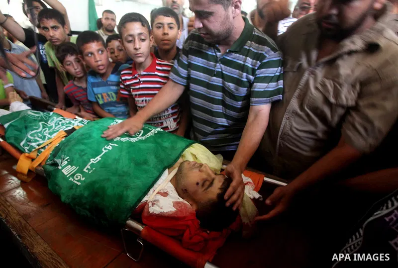Palestinians mourn over the body of Hamas militant Mahmud Al-Heggi during his funeral in the Al Zaitun area in the east of Gaza city, 12 July 2012. Al Heggi was killed and others wounded after an Israeli air strike in AL...