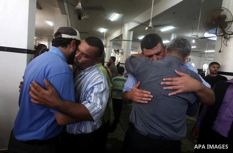 Palestinians mourn over the body of Hamas militant Mahmud Al-Heggi during his funeral in the Al Zaitun area in the east of Gaza city, 12 July 2012. Al Heggi was killed and others wounded after an Israeli air strike in AL...