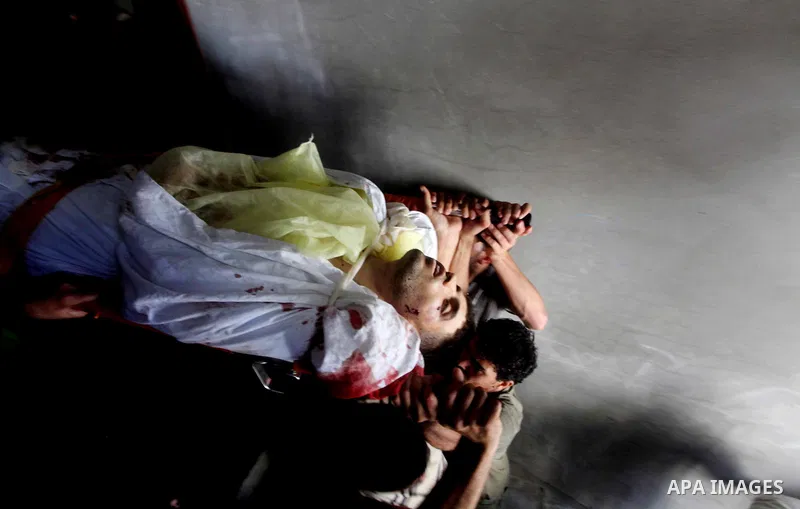 Palestinian mourners carry the body of Hamas militant Mahmud Al-Heggi during his funeral in the Al Zaitun area in the east of Gaza city, 12 July 2012. Al Heggi was killed and others wounded after an Israeli air strike in...