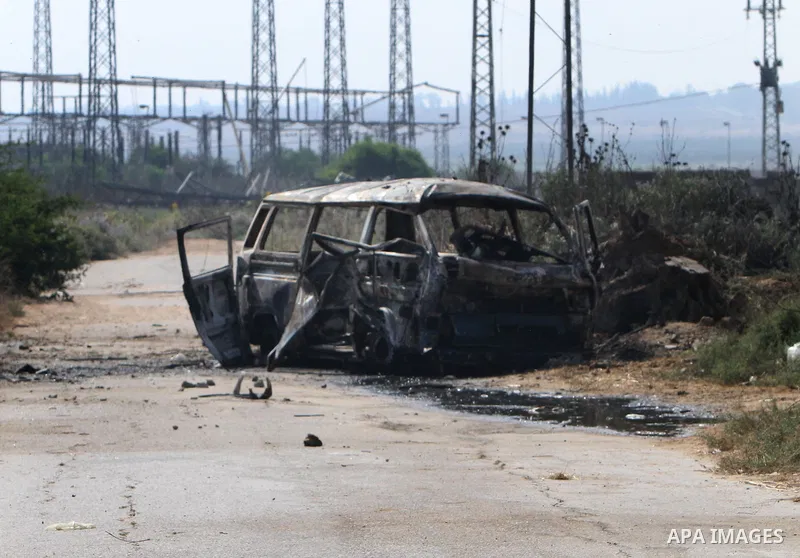 Palestinians inspect a destroyed vehicle following an Israeli bombing in Gaza City on July 12, 2012. A Palestinian was killed and others wounded after an Israeli air strike in al-Zeitoun area in the east of Gaza city on...