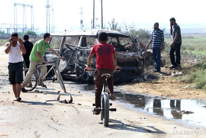 Palestinians inspect a destroyed vehicle following an Israeli bombing in Gaza City on July 12, 2012. A Palestinian was killed and others wounded after an Israeli air strike in al-Zeitoun area in the east of Gaza city on...