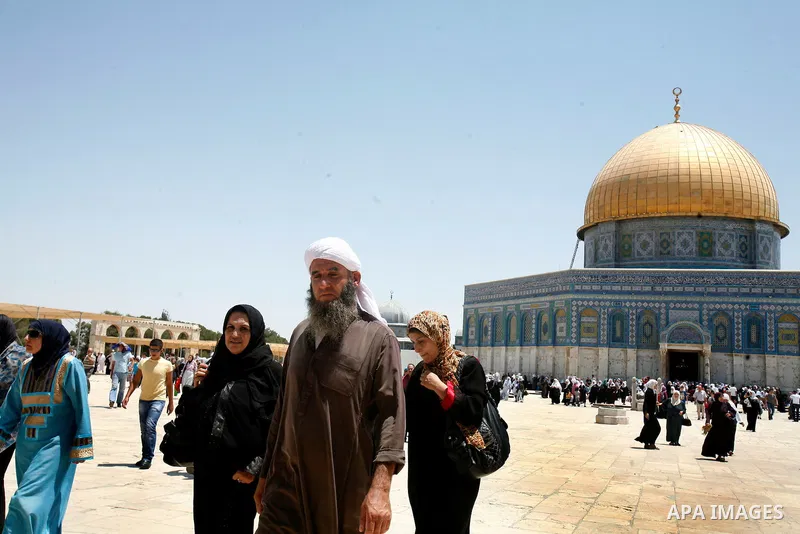 Palestinian Muslim worshippers walk in front of the Dome of Rock mosque during Friday prayers, in the Al Aqsa Mosque compound, in Jerusalem's old city on July 13, 2012. Photo by Mahfouz Abu Turk