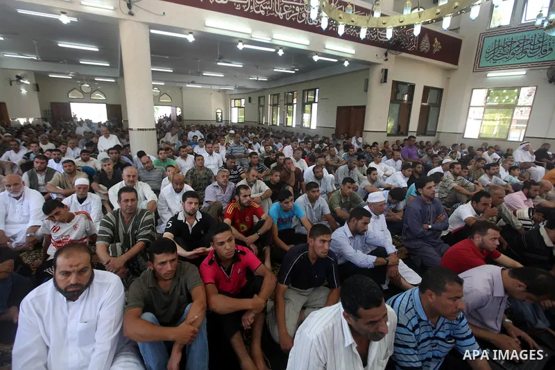 Palestinians listen to Palestinian Prime Minister in Gaza Ismail Haniyeh speech during Friday prayer in Gaza City on 13 July 2012.. Photo by Majdi Fathi