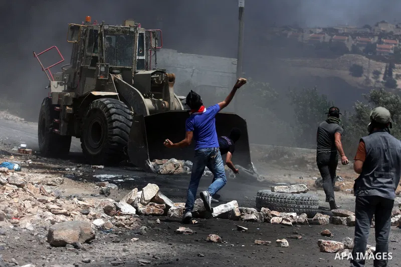 Palestinian protesters throw stones at Israeli truck during clashes following a weekly protest against the nearby Jewish settlement of Kdumim, in the West Bank village of Kufr Qaddum, near Nablus July 13, 2012. According...