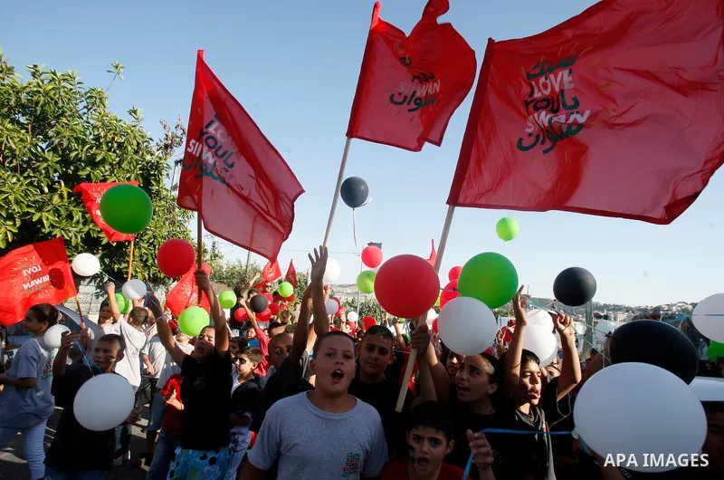 Palestinian children hold balloons and placards during a rally on 13 July, 2012 in the east Jerusalem neighborhood of Silwan against Jewish settlement and the judaization in Palestinian districts of the holy city. Photo...