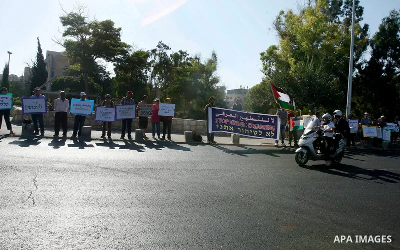 Activists hold signs asking for justice for the residents of Sheikh Jarrah on 13 July, 2012. Foreign activists, Israeli activists and Palestinians participate in the weekly march with the people of the Sheikh Jarrah neig...