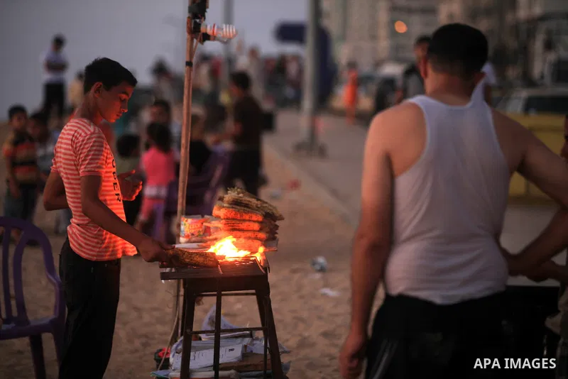 A Palestinian vendor sells grilled corn at Gaza beach on 13 July 2012 in Gaza City. Photo by Majdi Fathi