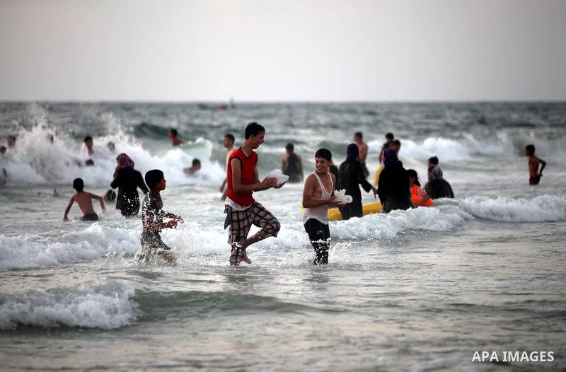 Palestinians enjoy swimming in the sea at Gaza beach on 13 July 2012 in Gaza City. Photo by Majdi Fathi
