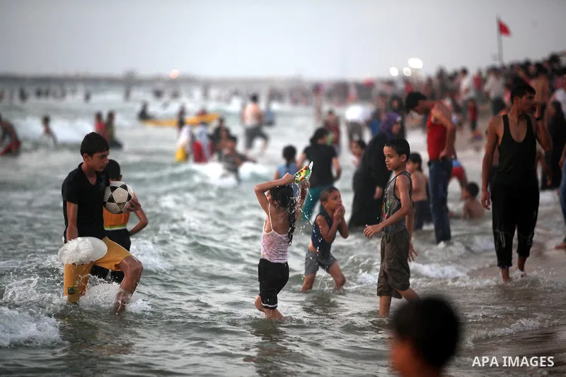 Palestinians enjoy swimming in the sea at Gaza beach on 13 July 2012 in Gaza City. Photo by Majdi Fathi