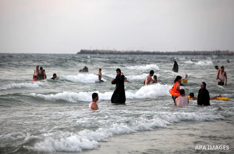 Palestinians enjoy swimming in the sea at Gaza beach on 13 July 2012 in Gaza City. Photo by Majdi Fathi