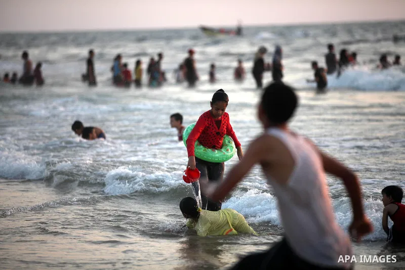 Palestinians enjoy swimming in the sea at Gaza beach on 13 July 2012 in Gaza City. Photo by Majdi Fathi
