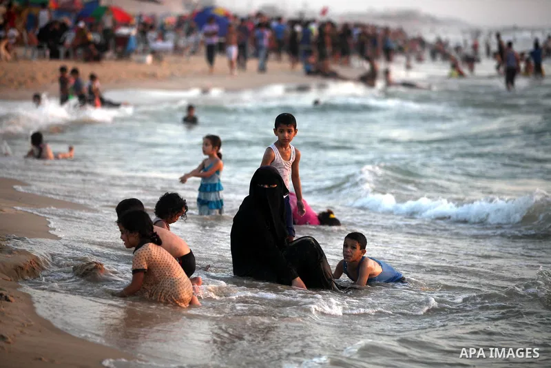 Palestinians enjoy swimming in the sea at Gaza beach on 13 July 2012 in Gaza City. Photo by Majdi Fathi