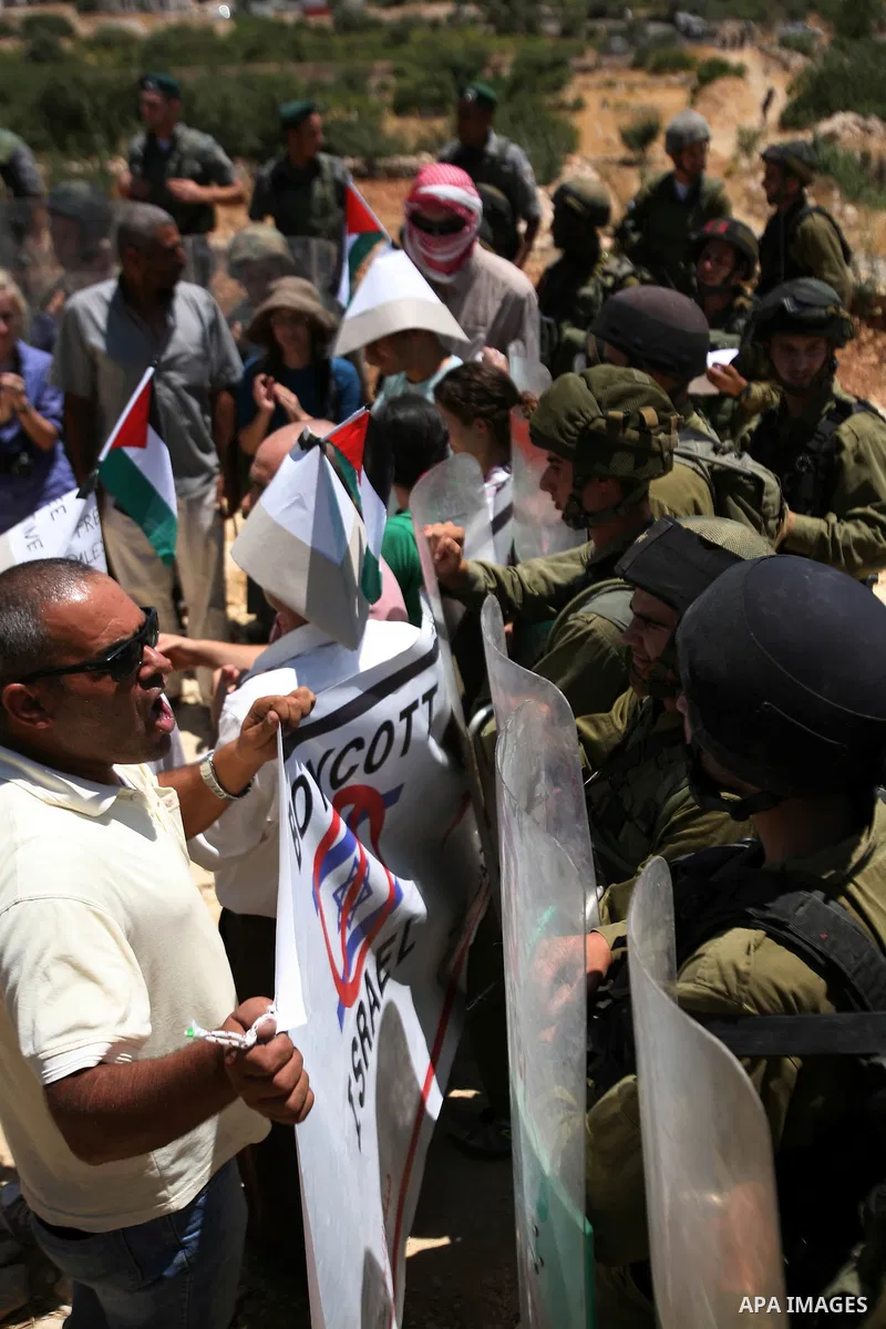 Palestinian and international demonstrators protest in the West Bank village of Susya, south Hebron, against pending demolition orders given by the Israeli Army, to demolish the village entrance, 14 July 2012. Photo by M...