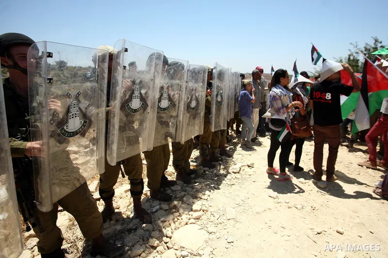 Palestinian and international demonstrators protest in the West Bank village of Susya, south Hebron, against pending demolition orders given by the Israeli Army, to demolish the village entrance, 14 July 2012. Photo by M...