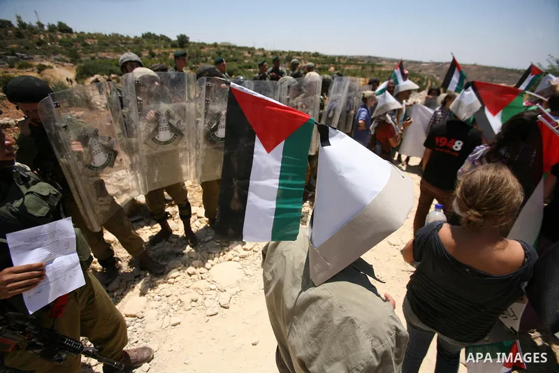 Palestinian and international demonstrators protest in the West Bank village of Susya, south Hebron, against pending demolition orders given by the Israeli Army, to demolish the village entrance, 14 July 2012. Photo by M...