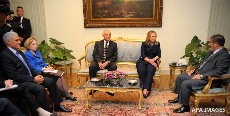 Egyptian Foreign Minister Mohammed Kamel Amr, U. S. Secretary of State Hillary Clinton, and Egyptian President Mohammed Morsi, during a photo opportunity at their meeting at the Presidential palace in Cairo, Egypt, Satur...