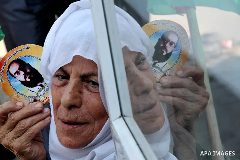 A Palestinian woman holds picture of her son during a protest calling for the release of prisoners held in Israeli jails in front of the headquarters Red Cross in Gaza City, on July.16, 2012. Photo by Ashraf Amra