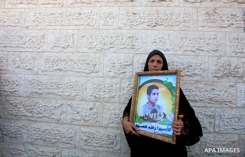 A Palestinian woman holds picture of her son during a protest calling for the release of prisoners held in Israeli jails in front of the headquarters Red Cross in Gaza City, on July.16, 2012. Photo by Ashraf Amra