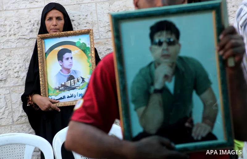 A Palestinian woman holds picture of her son during a protest calling for the release of prisoners held in Israeli jails in front of the headquarters Red Cross in Gaza City, on July.16, 2012. Photo by Ashraf Amra