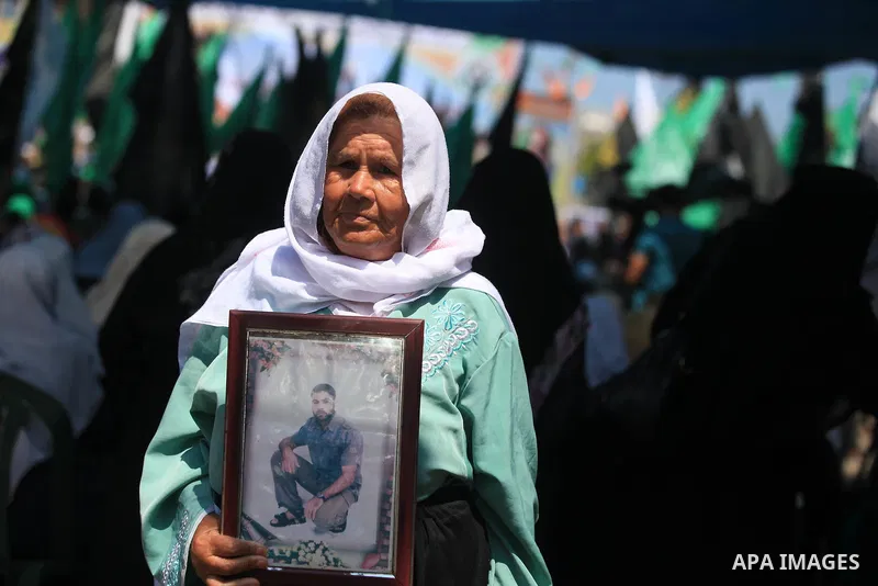 A Palestinian woman holds picture of her son during a protest calling for the release of prisoners held in Israeli jails in front of the headquarters Red Cross in Gaza City, on July.16, 2012. Photo by Majdi Fathi