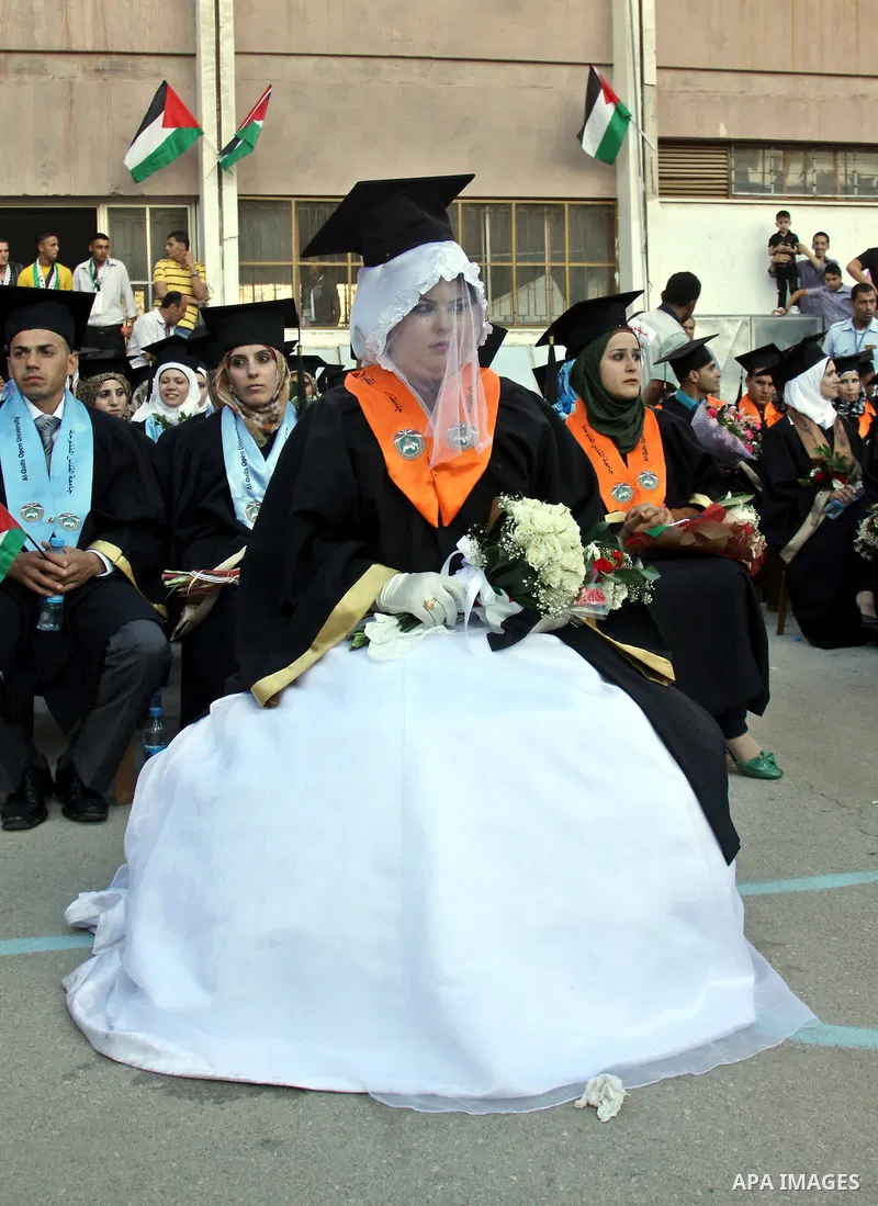 Palestinian bride celebrates her marriage during graduation ceremony at Al-Quds Open University in the West Bank city of Nablus, on July 16, 2012. Photo by Nedal Eshtayah