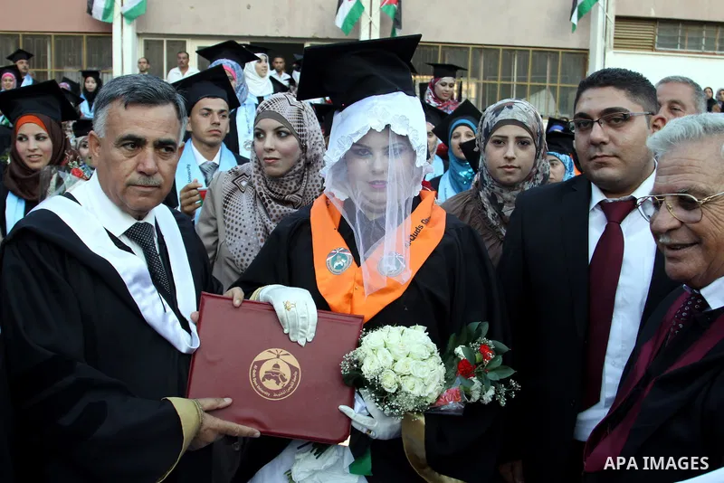Palestinian bride celebrates her marriage during graduation ceremony at Al-Quds Open University in the West Bank city of Nablus, on July 16, 2012. Photo by Nedal Eshtayah