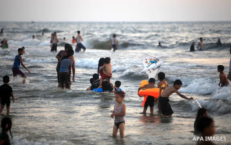 Palestinians enjoy swimming in the sea at Gaza beach during hot weather in Gaza city, July 16, 2012. The temperature of the Gaza strip reaches more than 33 degrees Celsius and 61% humidity, Gazans escape to the beach and...