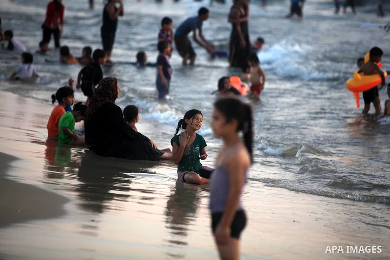 Palestinians enjoy swimming in the sea at Gaza beach during hot weather in Gaza city, July 16, 2012. The temperature of the Gaza strip reaches more than 33 degrees Celsius and 61% humidity, Gazans escape to the beach and...