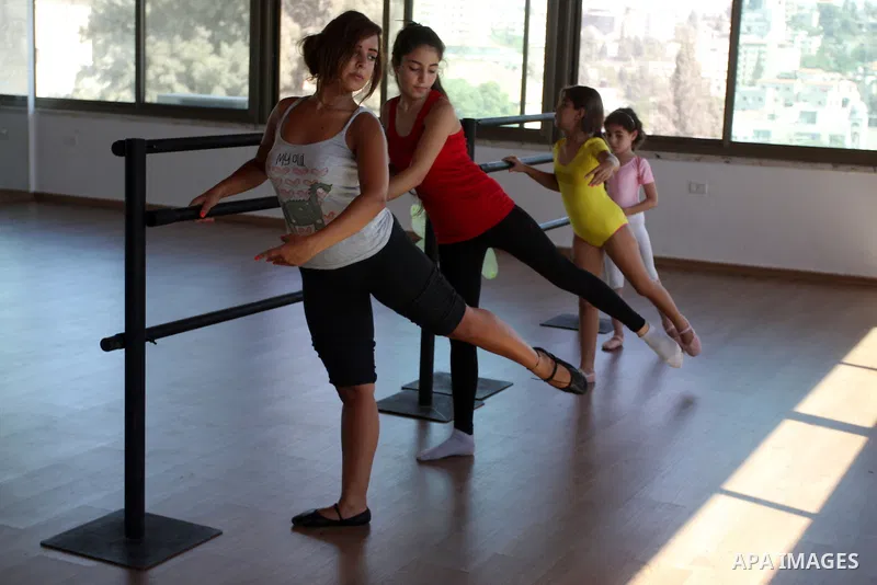 Palestinian girls lean on bars during a ballet class at the Ramallah Ballet Center dance school in the West Bank city of Ramallah July 17, 2012. The center is the first in the occupied West Bank. Photo by Issam Rimawi