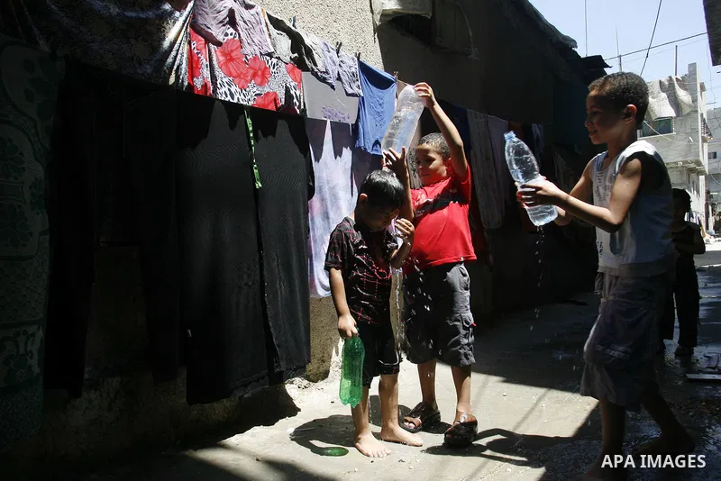 Palestinian children bathe outside their home in the Rafah refugee camp in the southern Gaza Strip on July 17, 2012. The temperature of the Gaza strip reaches more than 35 degrees Celsius and 50% humidity, Gazans escape...