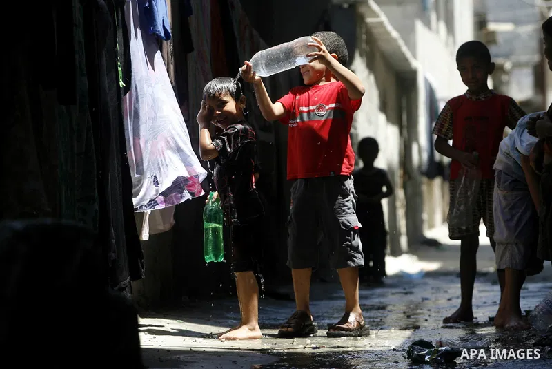 Palestinian children bathe outside their home in the Rafah refugee camp in the southern Gaza Strip on July 17, 2012. The temperature of the Gaza strip reaches more than 35 degrees Celsius and 50% humidity, Gazans escape...