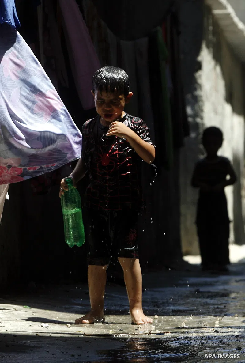 Palestinian children bathe outside their home in the Rafah refugee camp in the southern Gaza Strip on July 17, 2012. The temperature of the Gaza strip reaches more than 35 degrees Celsius and 50% humidity, Gazans escape...