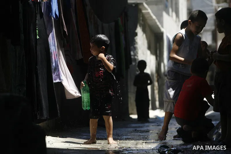 Palestinian children bathe outside their home in the Rafah refugee camp in the southern Gaza Strip on July 17, 2012. The temperature of the Gaza strip reaches more than 35 degrees Celsius and 50% humidity, Gazans escape...