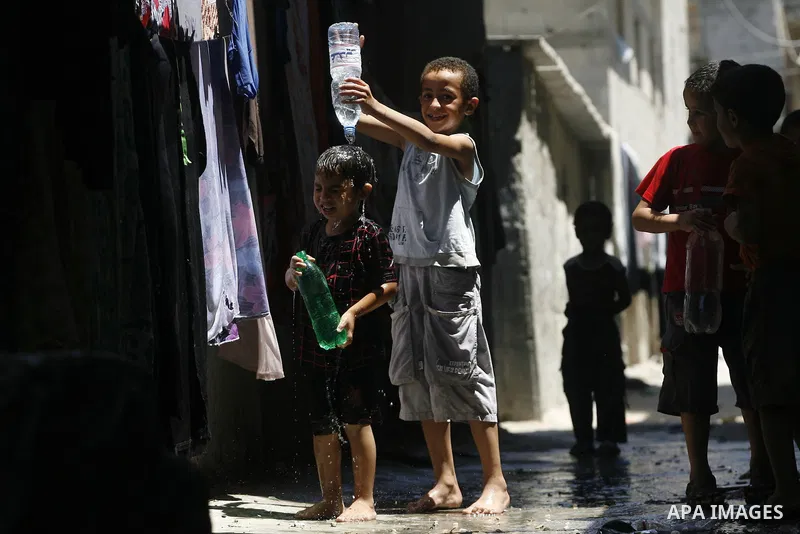 Palestinian children bathe outside their home in the Rafah refugee camp in the southern Gaza Strip on July 17, 2012. The temperature of the Gaza strip reaches more than 35 degrees Celsius and 50% humidity, Gazans escape...